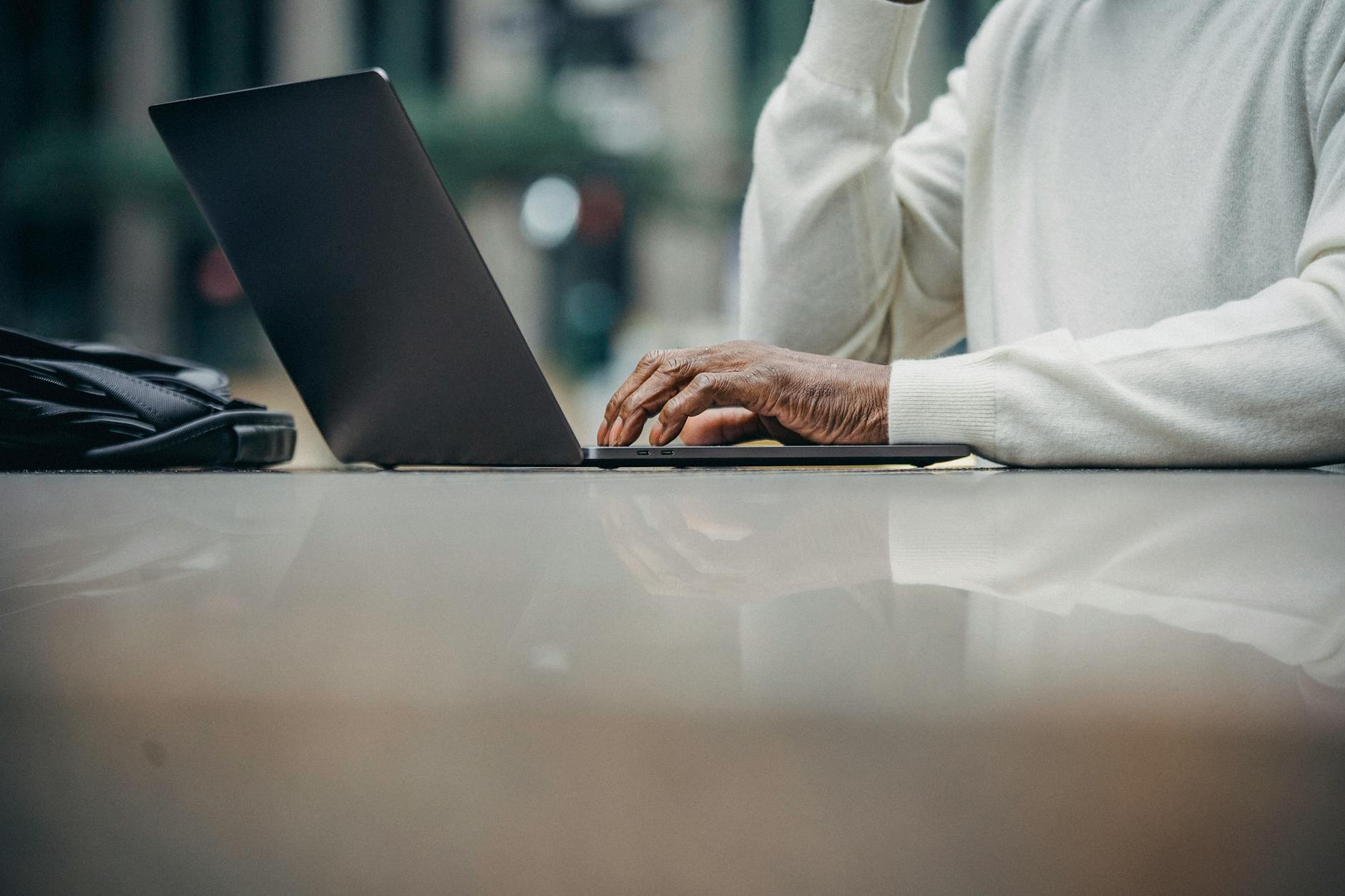 Nicht Erkennbarer Afroamerikanischer Mann, Der Laptop Im Straßencafé Benutzt