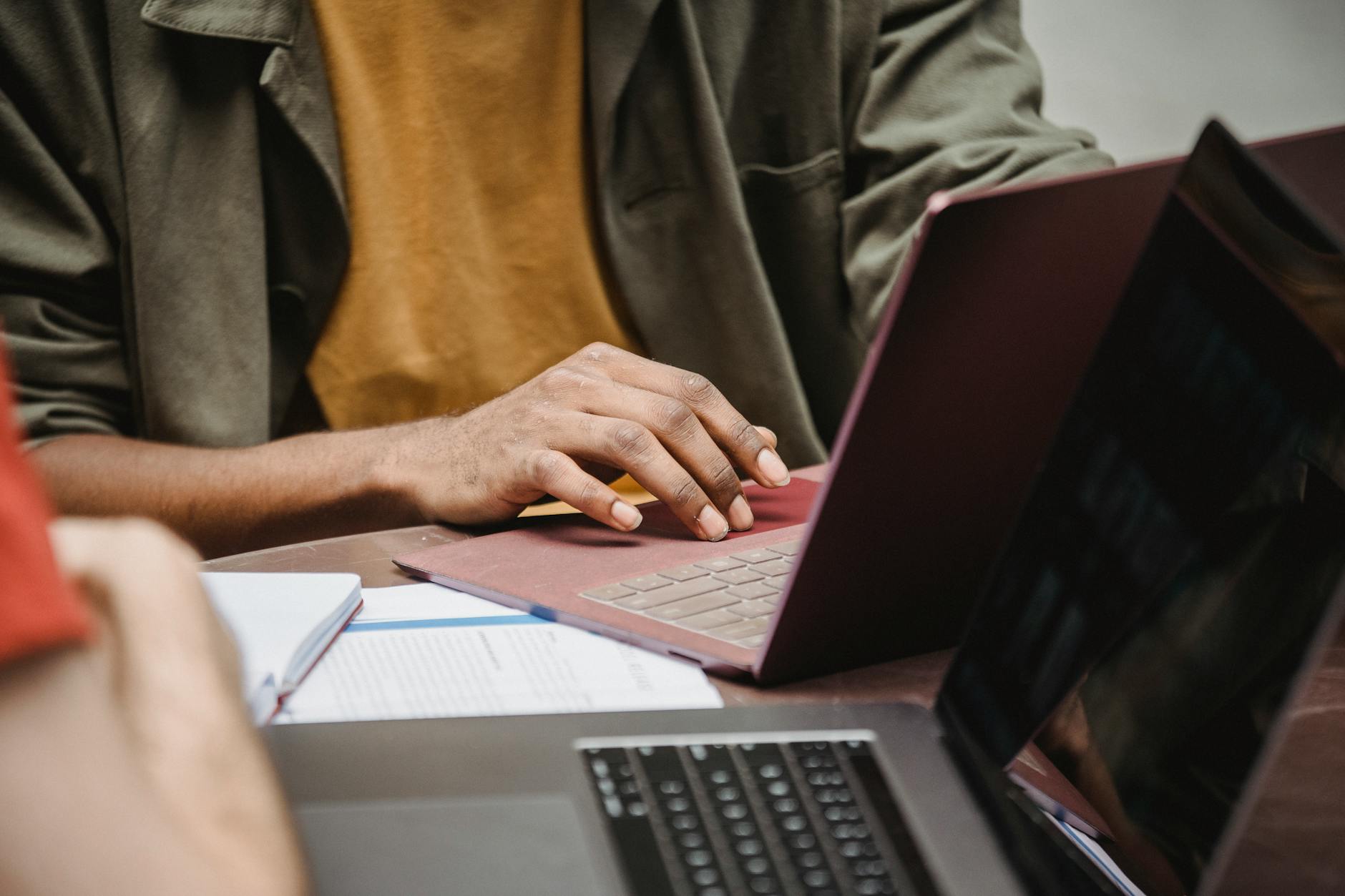 Person In Brown Button Up Shirt Mit Macbook Pro